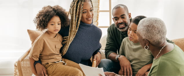 A three-generation family is happily sitting in a living room discussing the grandmother’s results.